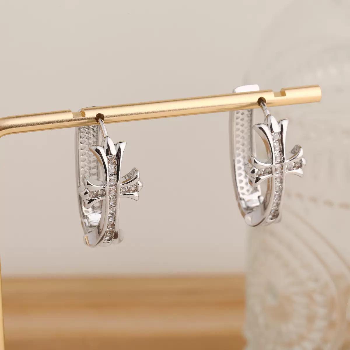 Silver Crystal Cross Hoop Earrings  hanging on a gold rod